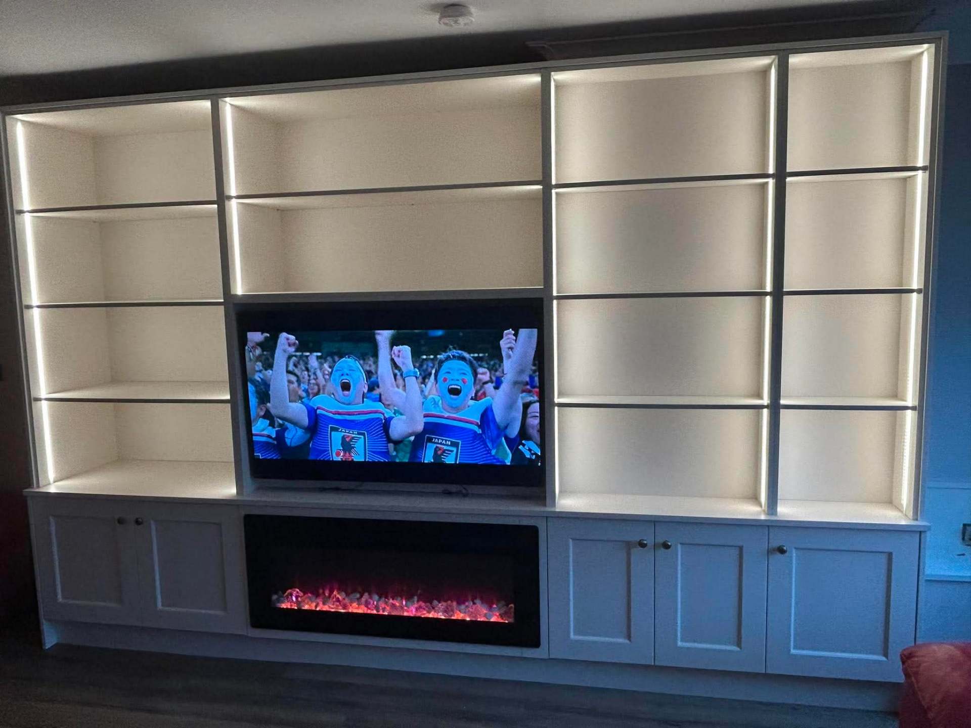 Full-wall cream shaker media unit with LED-lit display shelving, TV and long electric fire